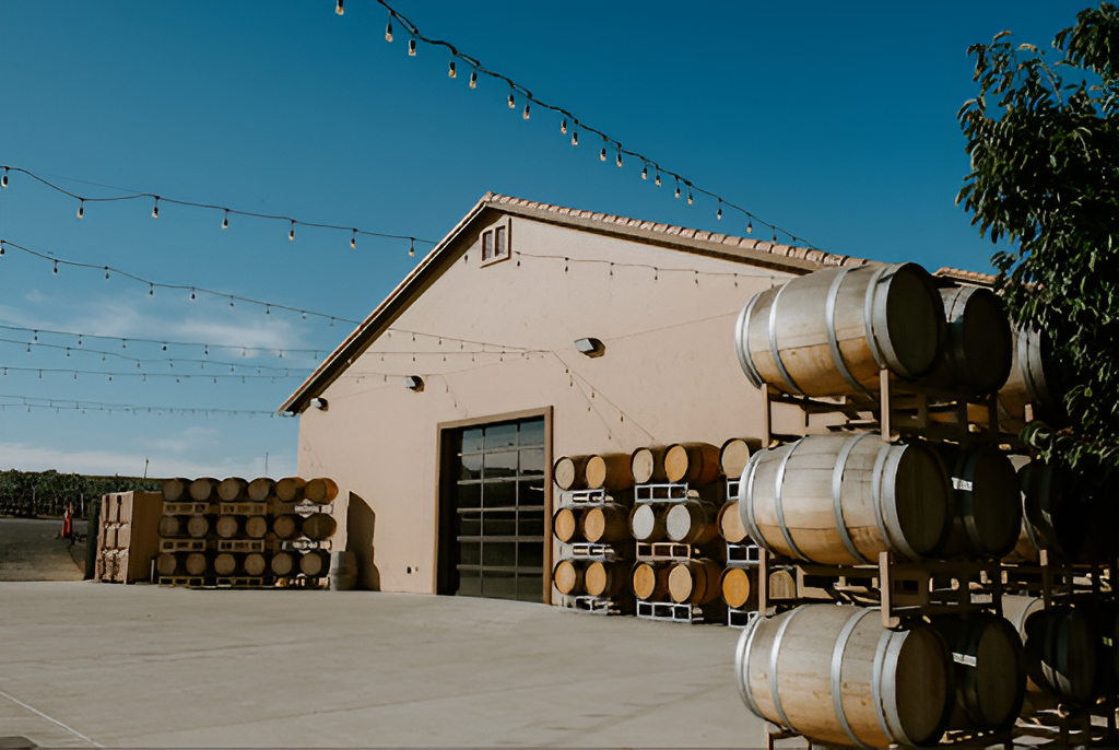 McGrail Vineyards winery building with wine barrels and string lights outside.