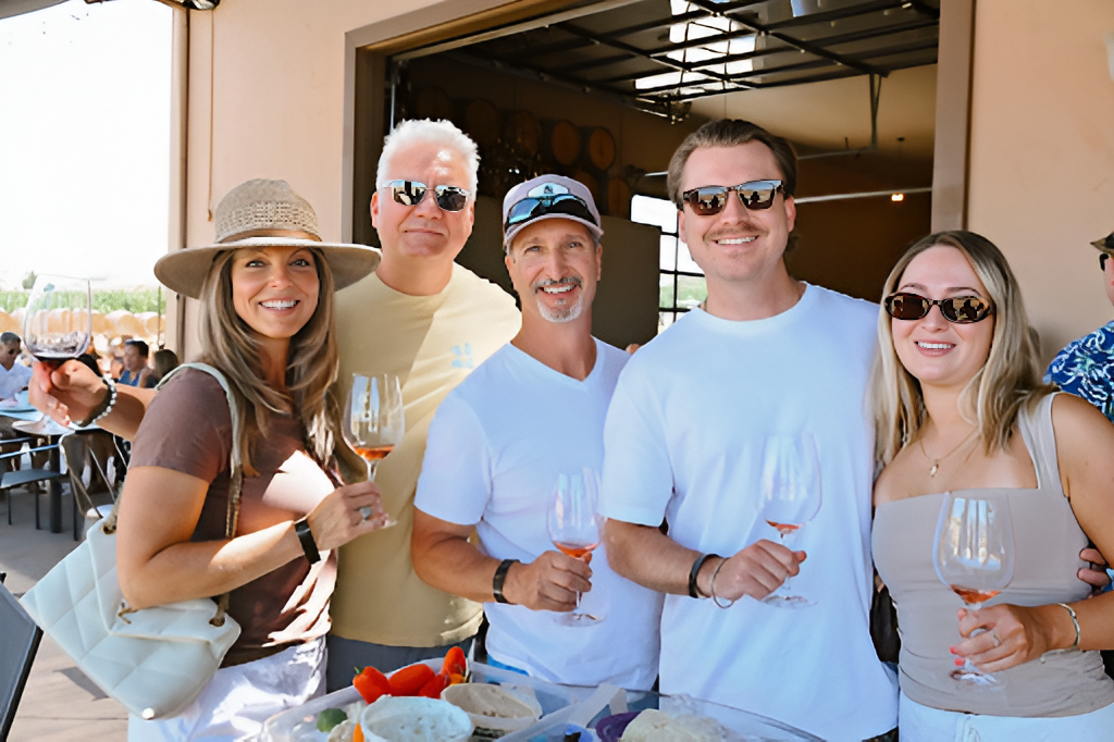 McGrail Vineyards guests holding wine glasses during a sunny wine club tasting event.