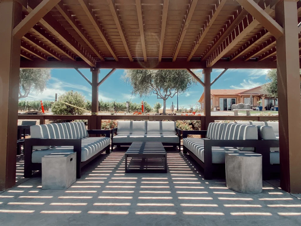 Covered outdoor lounge at McGrail Vineyards overlooking estate vineyards with shaded seating.